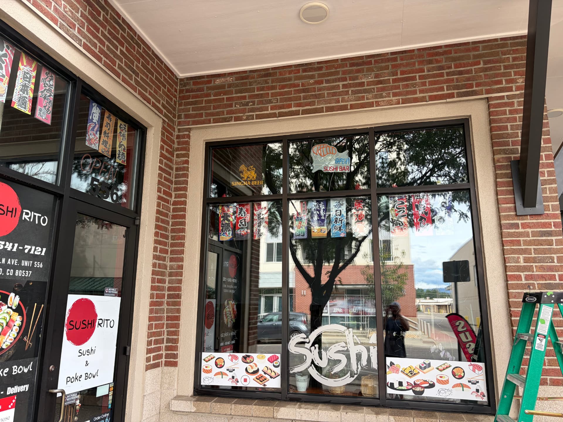 Exterior storefront glass cleaned along a brick building